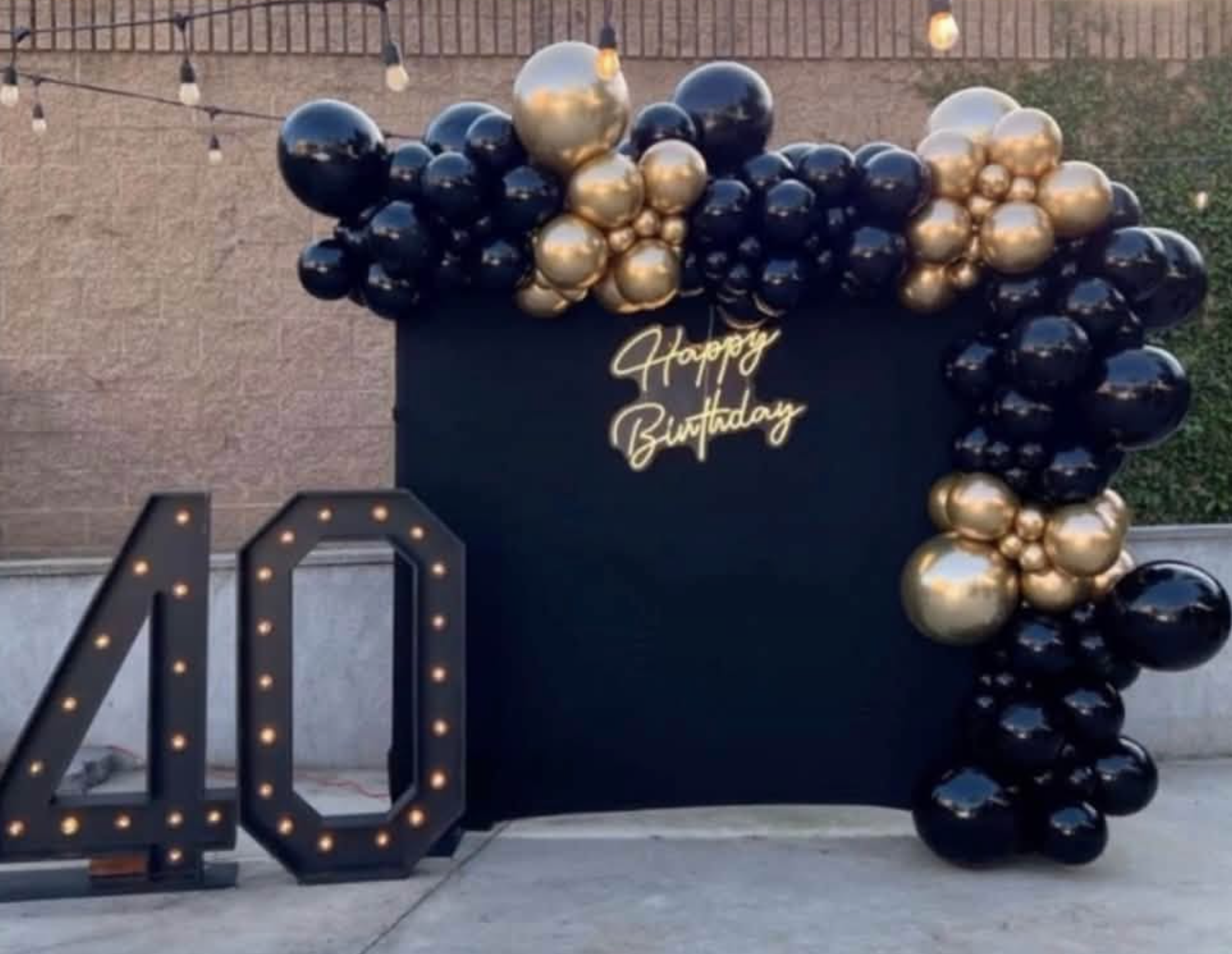 Black and gold balloon arch with light-up 40 numbers